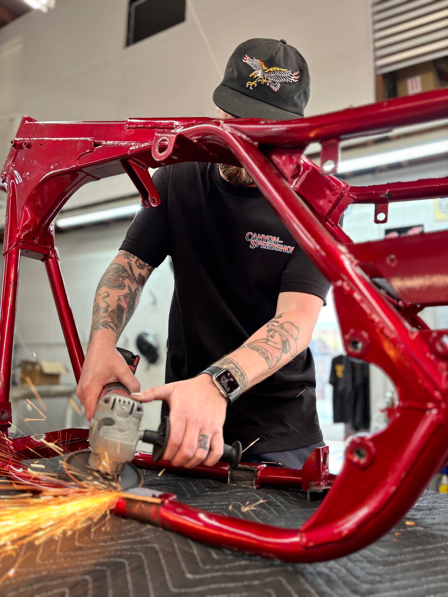 Eagle + Harley FXR t-shirt front. Man sawing FXR frame.